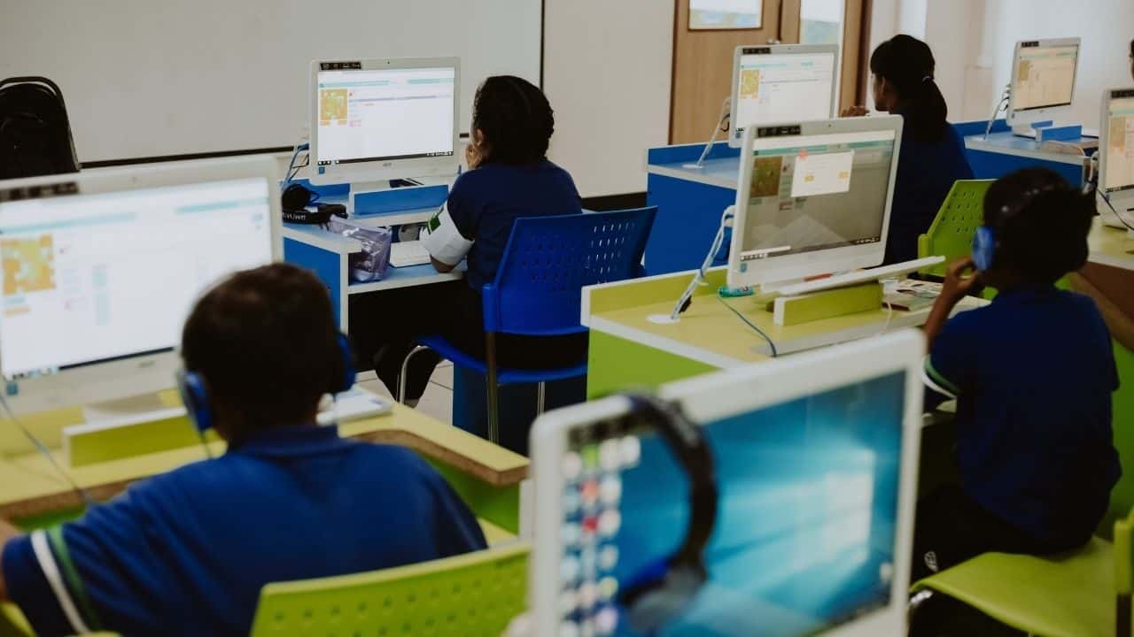 a group of people sitting in front of a computer